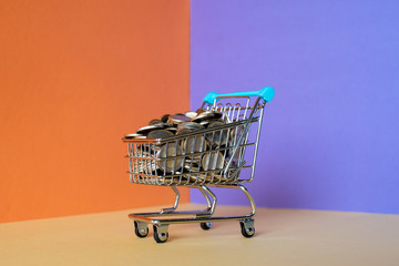 Miniature shopping cart full of coins