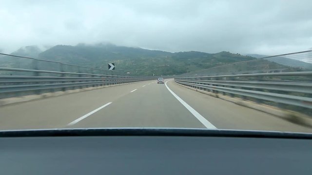 Driving over long curving bridge in Sicily, Italy. Autoroute E90 between Messina and Palermo, Sicily, Italy.