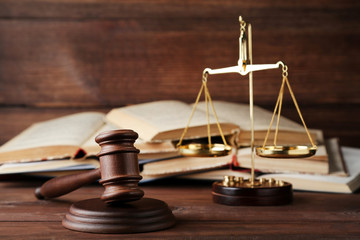 Judge gavel with scales and books on wooden table