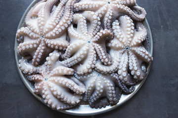 Fresh raw octopus on a large platter. Concept - healthy food, longevity, Mediterranean diet. A big catch.