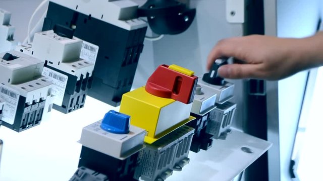 Person clicks pushing on the control panel buttons and pressing the lever close-up. Person tilts the lever to turn it on oa turn off. Control buttons panel close-up.