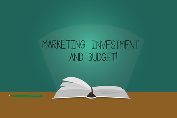 Writing note showing Marketing Investment And Budget. Business photo showcasing Invest money in advertising promotions Color Pages of Book on Table with Pen and Light Beam Glaring