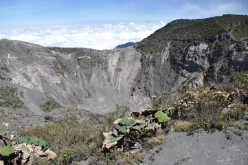 Irazu volcano in Costa Rica. Crater in clouds with protective barriers. Fragments of lava and pumice.