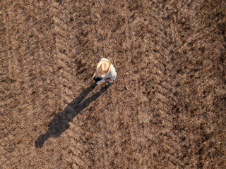 Top view of male farmer flying a drone in field