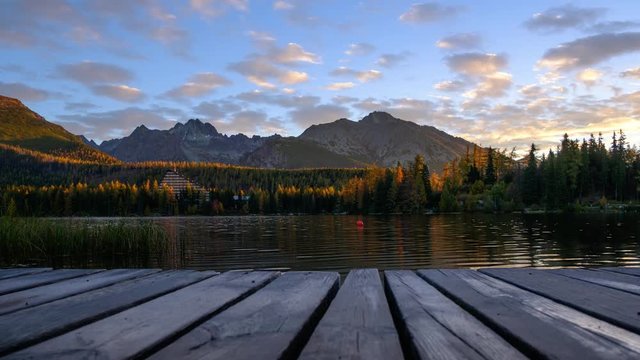 Picturesque autumn view of lake Strbske pleso in High Tatras National Park, Slovakia. Clear water with reflections of orange larch and high mountains on background. Timelapse video