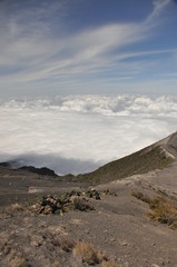 Irazu volcano in Costa Rica. Crater in clouds with protective barriers. Fragments of lava and pumice.