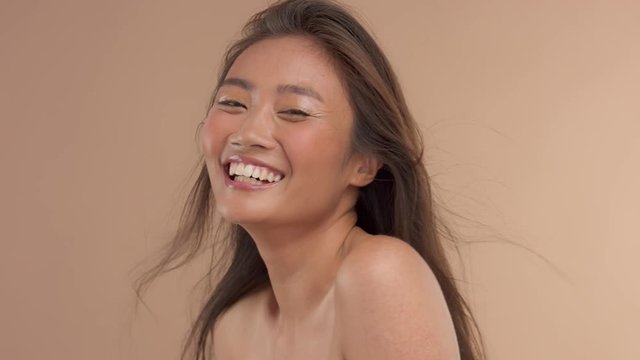 happy smiling and laughins thai asian model with straight hair moving in air