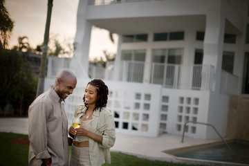 Smiling husband and wife standing together in the back yard.
