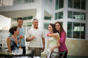 Family standing around a table in the back yard.