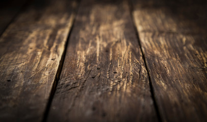 Brown wood scratched desk board texture. Selective focus. Close up. Abstract background, empty template, text space.