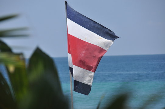 Flag of Costa Rica fluttering in the wind over the Pacific coast.