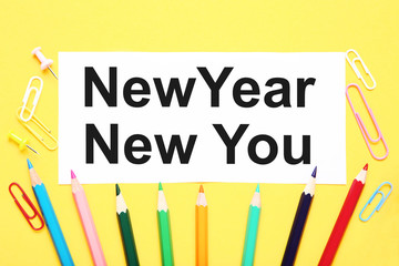 New year new you on sheet of paper with clips and colorful pencils