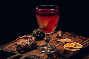 mulled red wine with spices and fruits on a wooden rustic table. Traditional hot drink at Christmas time