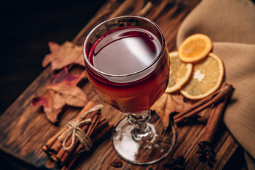 mulled red wine with spices and fruits on a wooden rustic table. Traditional hot drink at Christmas...
