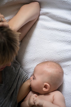 Mother breastfeeding on bed