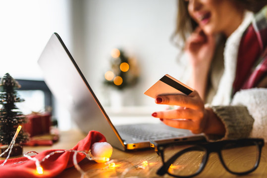 Young woman buying online at home  for winter holidays using laptop computer. Christmas holiday shopping