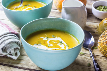Roasted pumpkin and carrot soup with cream and pumpkin seeds