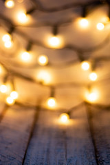 Defocused christmas background. Bokeh lights over wooden wihte rustic planks.