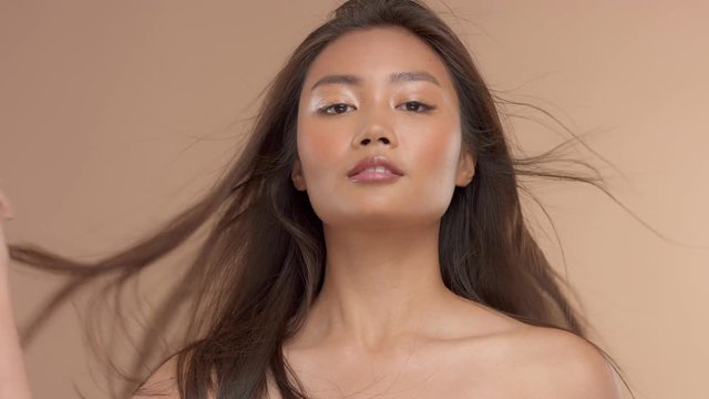thai asian model frontal to camera with straight shiny hair blowing in air