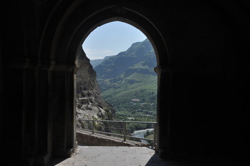 Fototapeta premium Old rock town in Vardzia, Georgia. The niches of the church and living quarters carved in a rock wall.