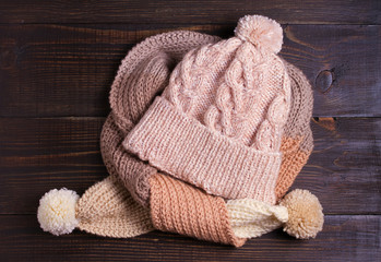 Fototapeta na wymiar Knitted hat and scarf, winter concept. Women winter warm accessories on wooden background. Flat lay, view from above, top