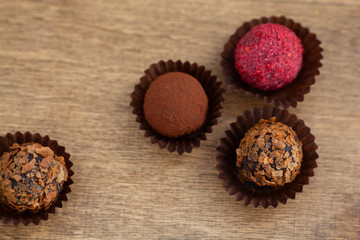 Belgian pralines from above on the wooden background with blank space on left side,selective focus and low key technique chocolate truffles on textured wooden background