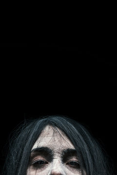 Creepy witch emerging from the darkness