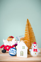 Christmas background. A small gold Christmas tree and boxes with gifts on a wooden table. Green background. Space for text. New Year's background.