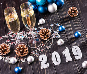 Composition with Christmas decorations and two champagne glasses, on bright background. New Year 2019 composition.