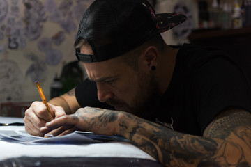 Tattooist drawing in salon