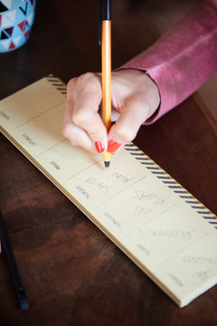 Woman writing agenda for the week.