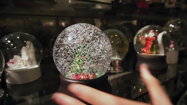 Beautiful winter snow globe with Christmas tree inside. Slow motion.