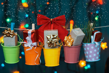 gifts boxes in buckets of colored garlands on lights background. Merry Christmas and Happy New Year card 