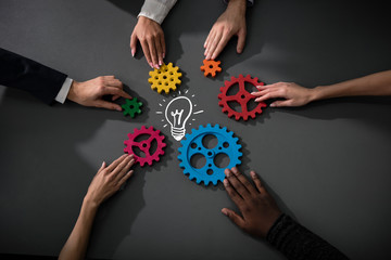 Business team connect pieces of gears to build a new creative idea. Teamwork, partnership and...
