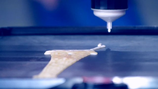 3d printer for liquid dough. 3D printer printing pancakes with liquid dough different shapes close-up. Modern additive technologies 4.0 industrial revolution. Gray blue white colors.