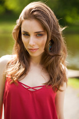 Closeup portrait of a young beautiful girl on summer background