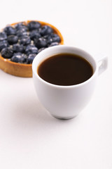 Tasty blueberry tart with vanilla cream and cup of coffee