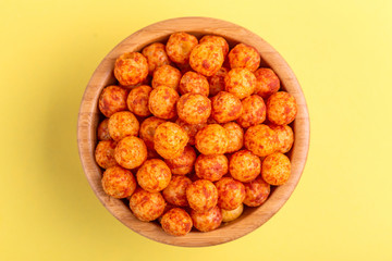 Bacon puff balls in wooden bowl on bright colorful background