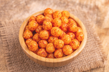 Bacon flavored corn puff balls in wooden bowl