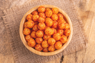Bacon flavored corn puff balls in wooden bowl