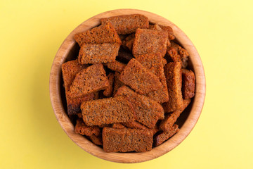 Rye salted crackers in wooden bowl on bright colored background