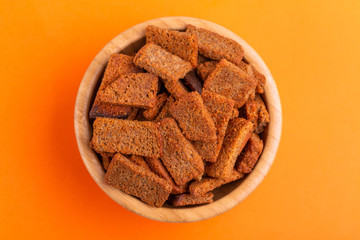Rye salted crackers in wooden bowl on bright colored background
