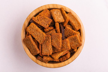 Rye salted crackers in wooden bowl on light marble background