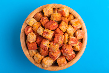 Bacon flavored crackers in wooden bowl on bright colored background