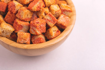 Bacon flavored crackers in wooden bowl on light marble background