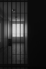 Dunkle Gefängniszelle mit Gitterstäben vor hellem Fensterlicht. 3D Rendering