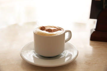 cup of coffee with whipped cream on light background