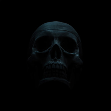 Black skull dimly lit against a black background