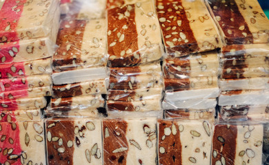 Soft Turron, Torrone or white nougat, a traditional Spanish and Italian sweet, chewy and sticky confection made of honey, sugar, toasted almonds and egg whites sold in slices at a Christmas market