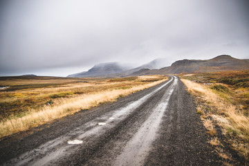 Gravel road in the snowy mountains of Iceland after a rainy day with mud